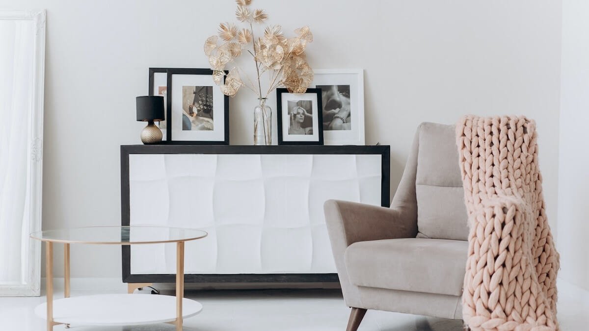 Quadros em uma sala de estar com poltrona e mesa de centro