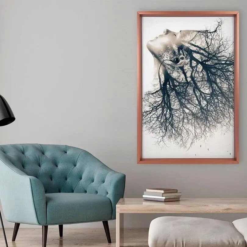Quadro com moldura marrom em uma parede de uma sala de estar com mesa de centro e poltrona verde claro
