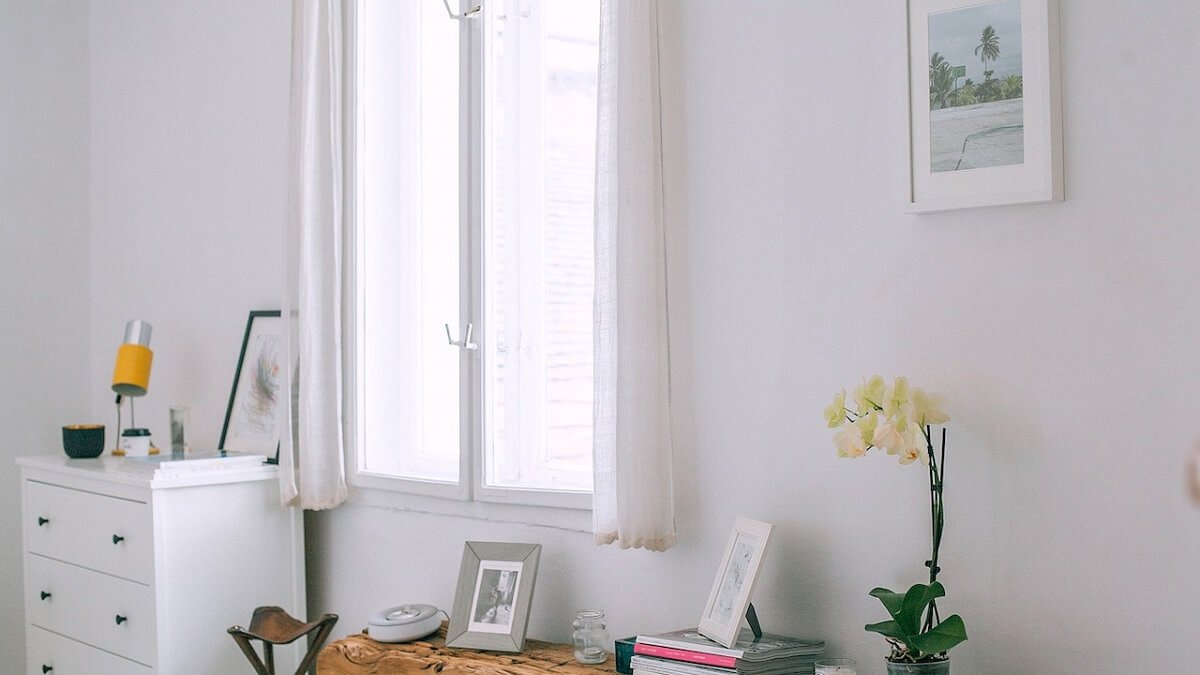Quadro em uma parede branca com bancada de estudos em quarto de casal