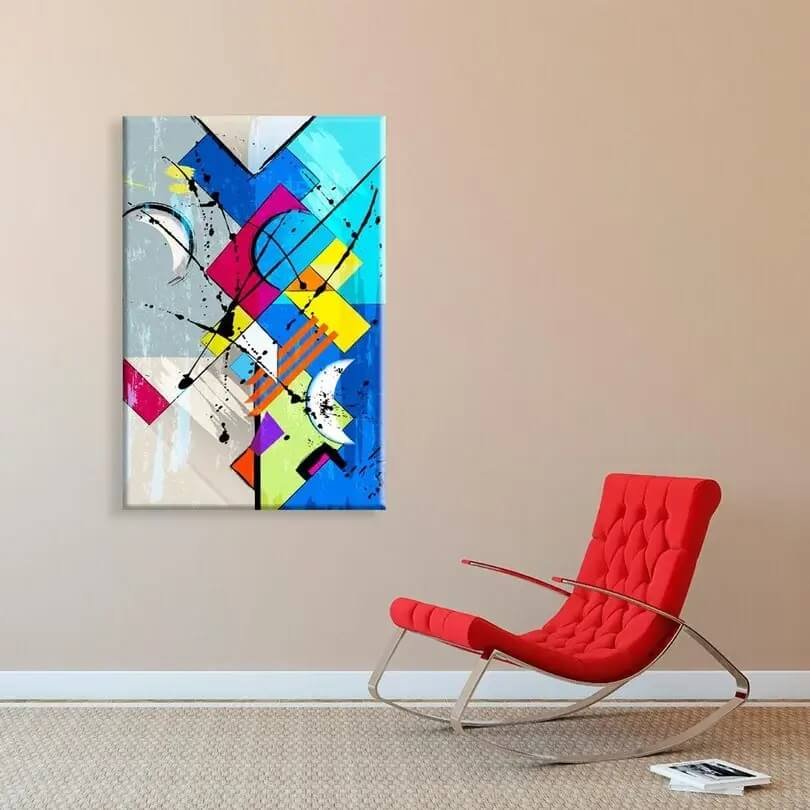 Quadro abstrato na parede de uma sala com uma poltrona vermelha