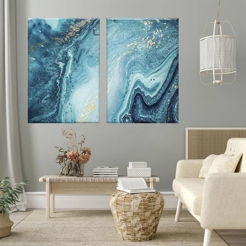 Quadro abstrato com tons de azul em uma sala com sofá, mesa de centro e outros móveis